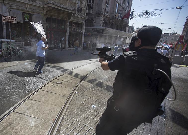 Стамбул, Турция. Сотрудник полиции стреляет пластиковыми пулями по протестующим против политики руководства страны