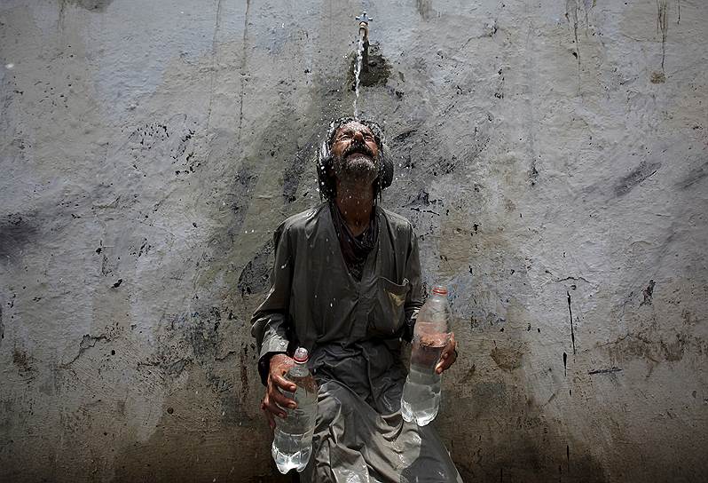 Карачи, Пакистан. Местный житель охлаждается во время небывало сильной жары, приведшей к смерти более 400 человек