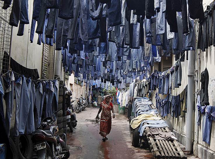 Калькутта, Индия. Джинсы, развешенные на улице для сушки перед продажей на рынке поношенной одежды