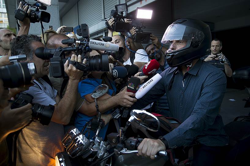 Афины, Греция. Министр финансов страны Янис Варуфакис, окруженный журналистами у выхода из здания министерства