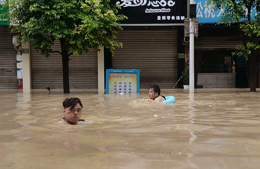 Тунжэнь, Китай. Люди плавают по затопленной улице после проливных дождей в провинции Гуйчжоу