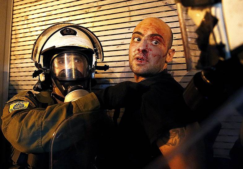 Афины, Греция. Раненый протестующий задержан полицией в ходе столкновений в центре города