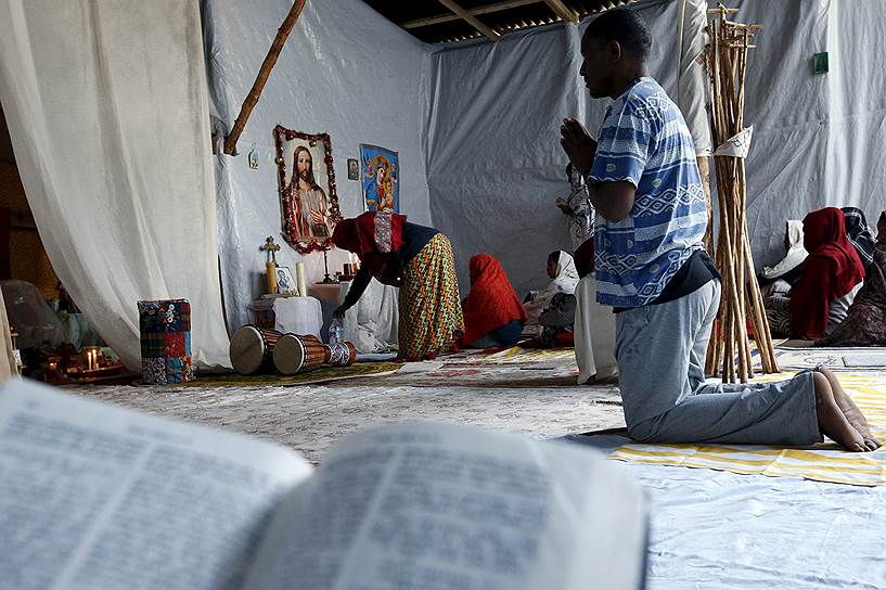 Беженцы-христиане из Эритреи и Эфиопии ежедневно молятся и читают Библию в импровизированной церкви