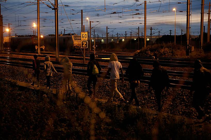 Кале, Франция. Мигранты идут вдоль железнодорожных путей возле тоннеля под Ла Маншем