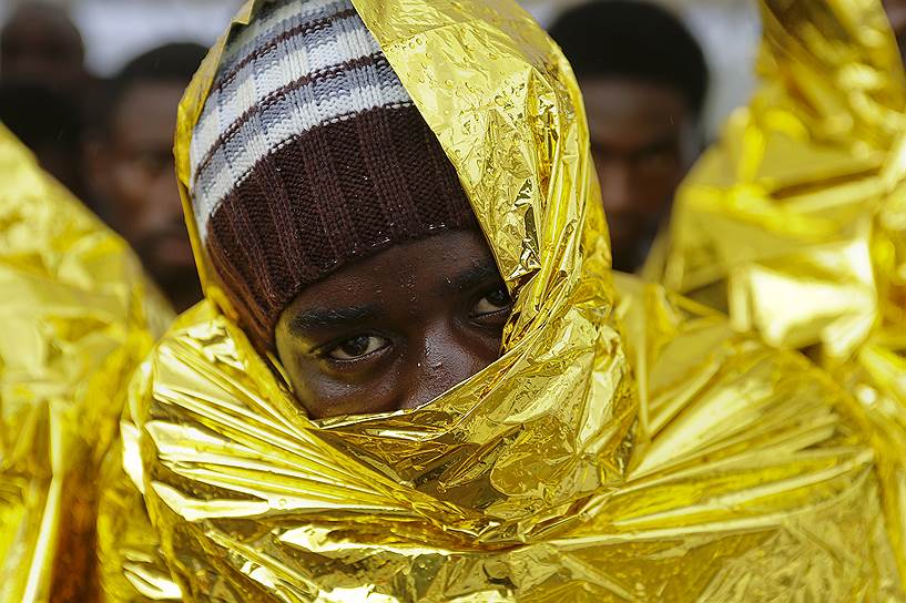 Мессина, Италия. Мигрант, ожидающий разрешения на высадку с корабля береговой охраны, спасшего более 300 человек, пытавшихся пересечь Средиземное море