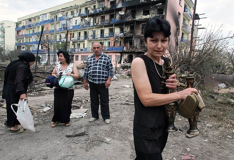 Местные жители во дворе своих разрушенных домов в городе Гори на востоке Грузии