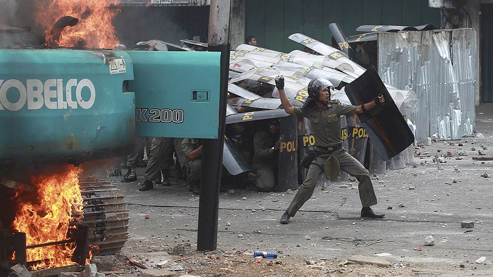Джакарта, Индонезия. Полицейские во время столкновений с протестующими против выселений в одном из районов города