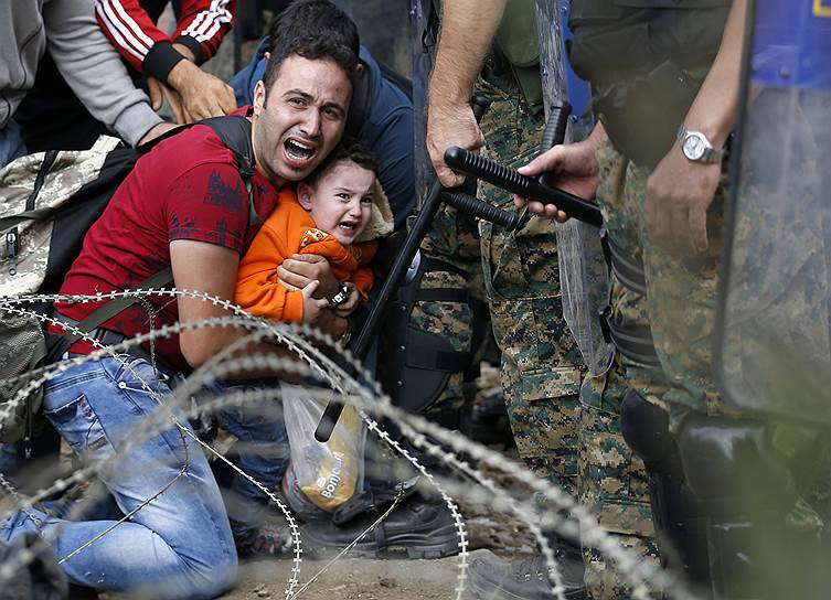 Идомени, Греция. Мужчина с ребенком во время столкновений между мигрантами и македонской полицией на границе с Грецией