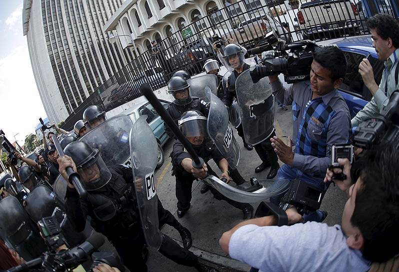 Гватемала, Гватемала. Полицейские противостоят журналистам, которые пытаются сфотографировать бывшего вице-президента страны Роксанну Бодетти