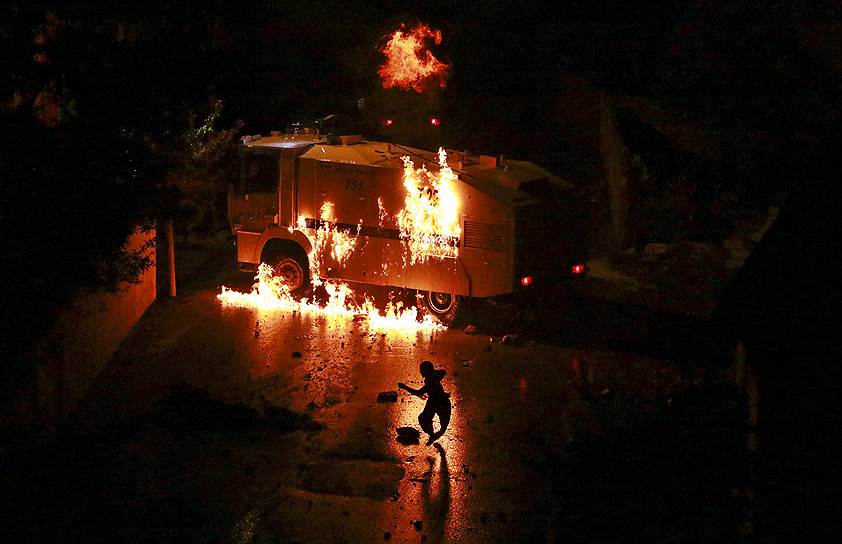 Ван, Турция. Горящий автомобиль полиции во время столкновений силовиков с курдскими боевиками