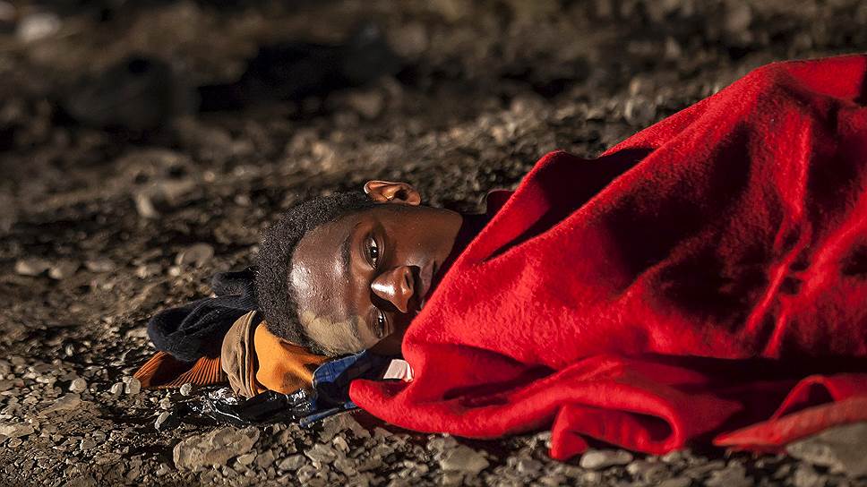 Гран Канариа, Испания. Африканский мигрант лежит на пляже после прибытия на территорию Испании на рыбацком судне