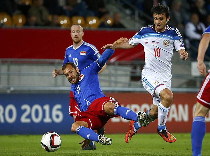 Алан Дзагоев борется за мяч с футболистом сборной Лихтенштейна