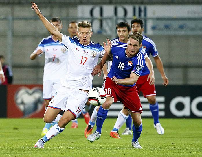 Олег Шатов борется за мяч с футболистом сборной Лихтенштейна