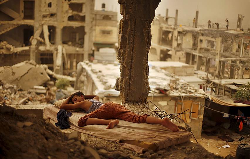 Газа, Палестина. Мальчик, спящий среди обломков своего дома, разрушенного во время войны с Израилем в 2014 году