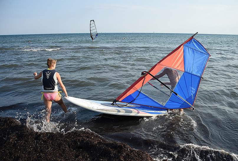 Отдыхающие во время занятий виндсерфингом в Черном море