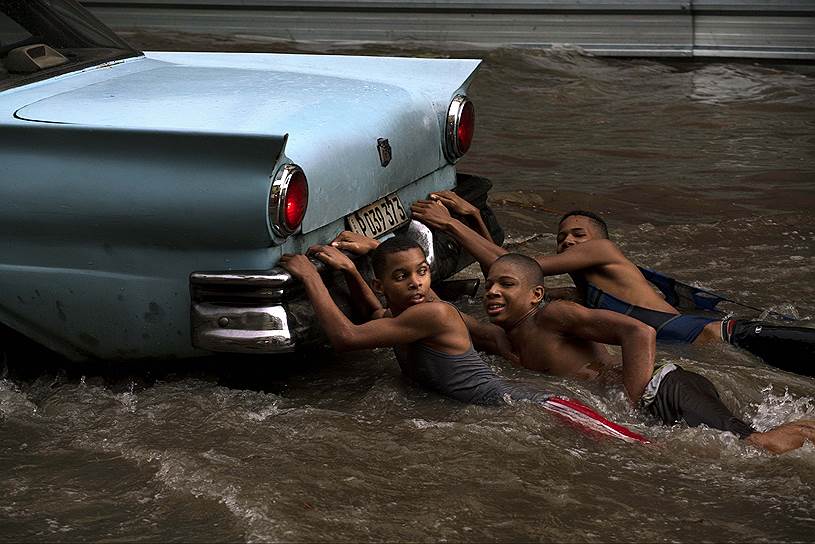 Гавана, Куба. Дети, играющие на затопленной после ливня улице 