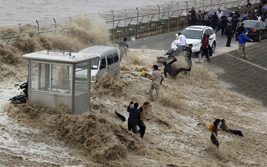 Ханчжоу, Китай. Люди, попавшие под приливную волну на реке Фучуньцзян