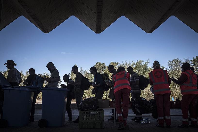 Беженцы получают еду и воду на границе с Австрией