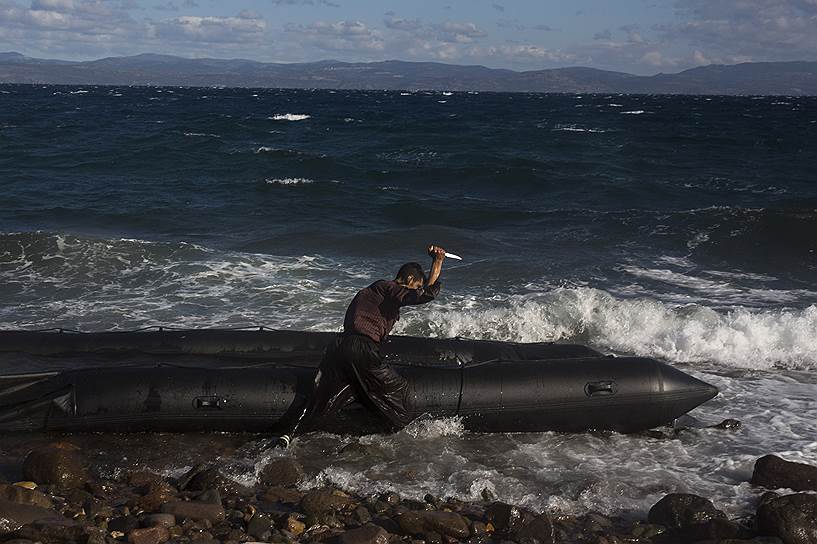 Лесбос, Греция. Мигрант из Афганистана портит ножом резиновую лодку, чтобы его не смогли отослать обратно