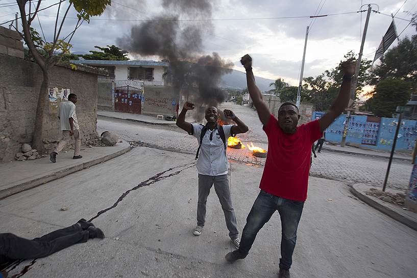 Порт-о-Пренс, Гаити. Сторонники кандидата в президенты Жана-Шарля Мойза рядом с телом своего единомышленника, застреленного во время демонстрации после объявления итогов выборов в стране