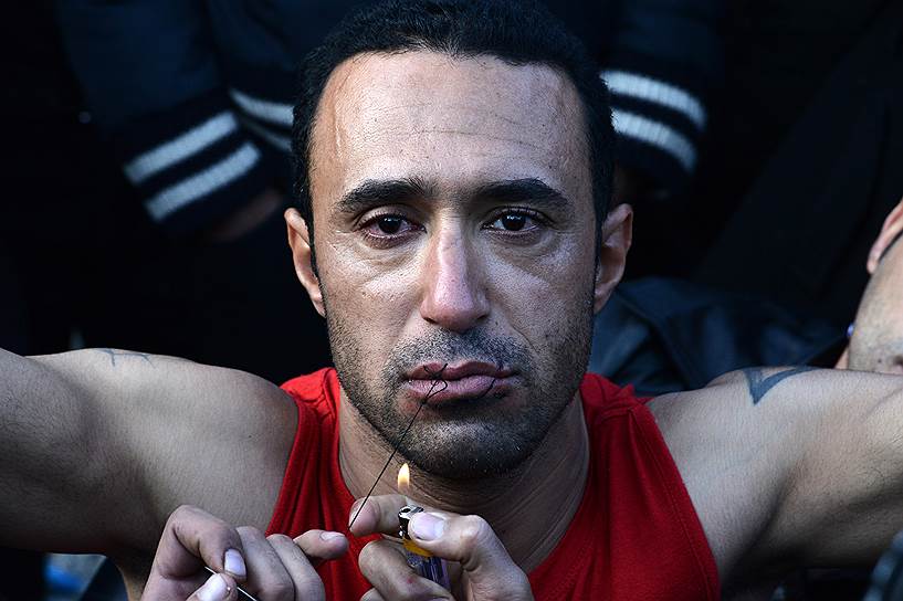 Идомени, Греция. Мигрант из Ирана зашивает рот в знак протеста против ужесточения правил пересечения границы с Македонией