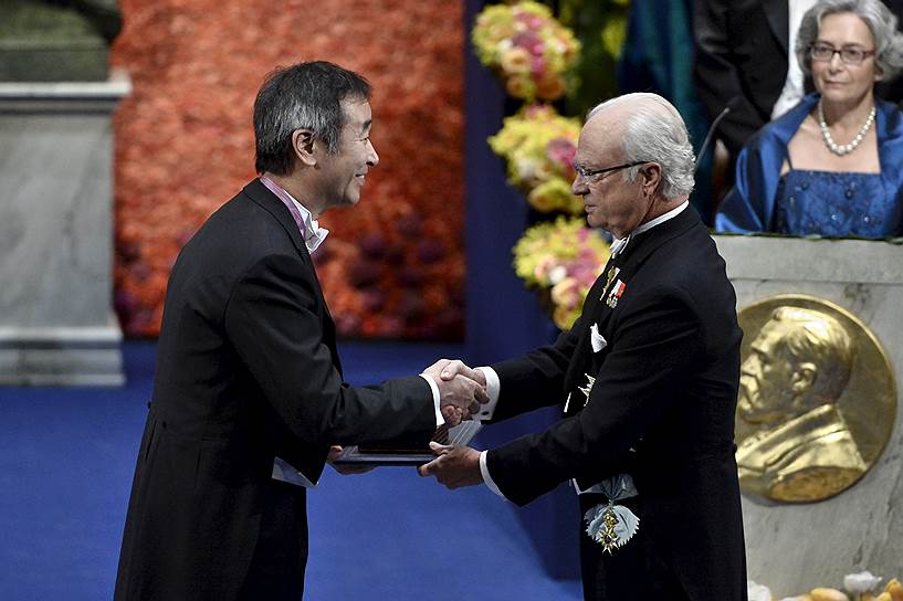 Лауреат Нобелевской премии по физике Такааки Кадзита получает награду из рук короля Швеции Карла XVI Густава