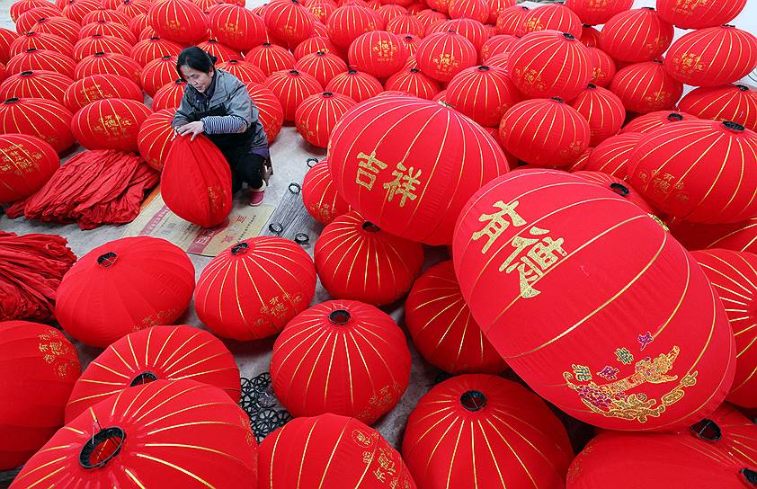 Провинция Хэнань, Китай. Рабочий делает фонари к празднованию Нового года