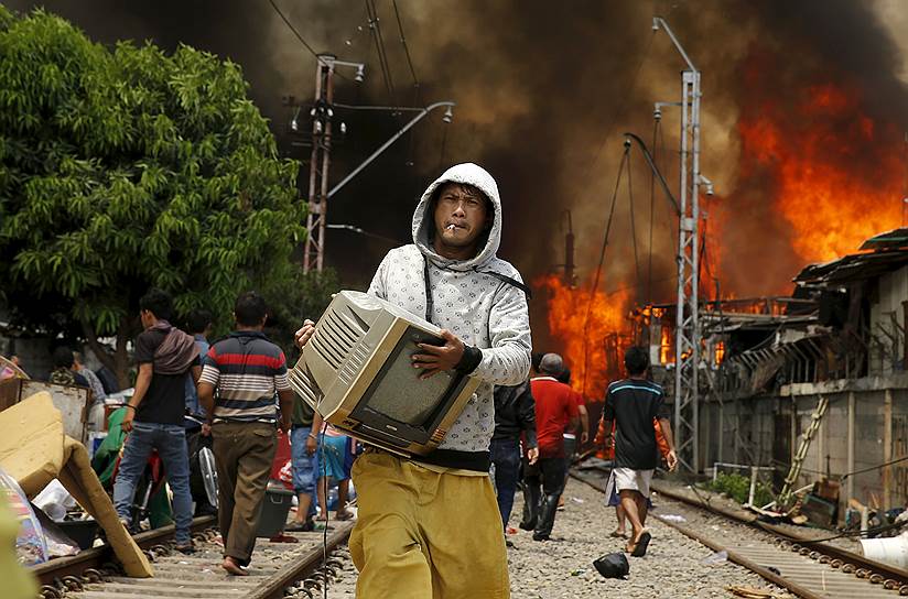 Джакарта, Индонезия. Местные жители, спасающие свои пожитки от пожара, охватившего трущобный район
