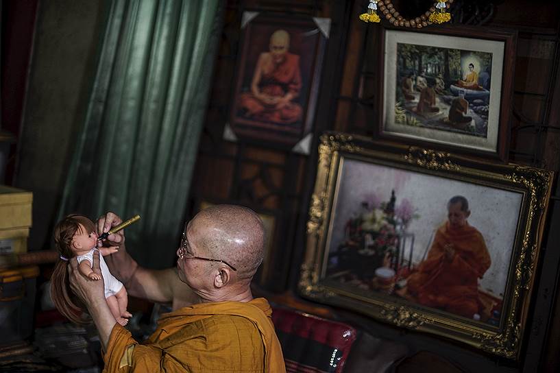 На фото: 64-летний буддийский монах Пхра Винаи Тхидтапануо благословляет куклу в одном из храмов в Нонтхабури, Таиланд