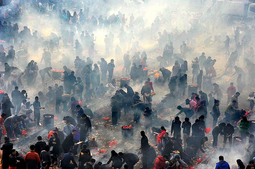 Ухань, Китай. Люди, возжигающие благовония во время пятого дня Нового года по лунному календарю