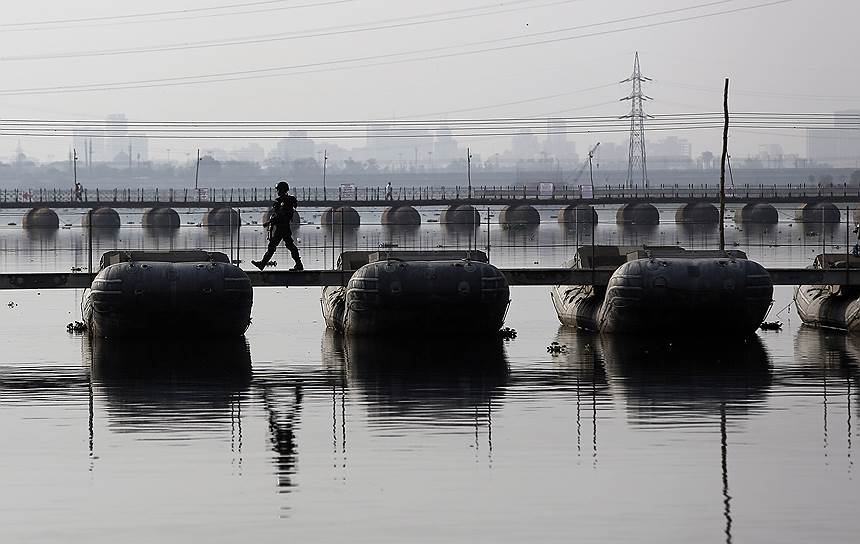 Дели, Индия. Сотрудник полиции на понтонном мосту через реку Джамна