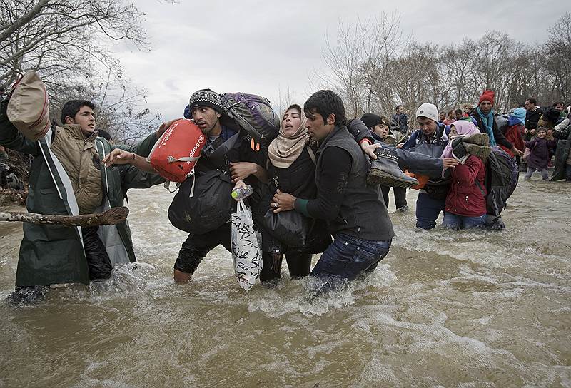 Греция. Мигранты, пересекающие реку вброд, чтобы проникнуть на территорию Македонии в обход установленных на границе заборов
