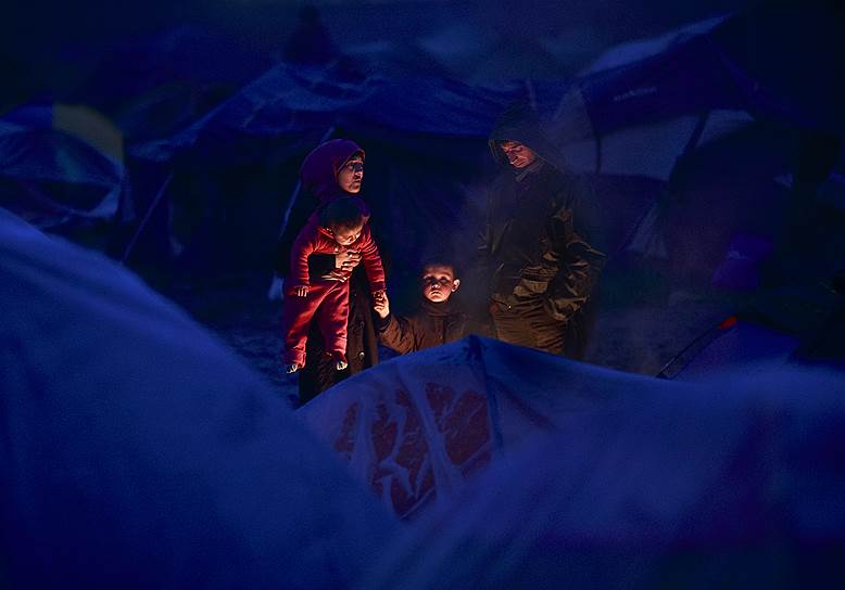 Идомени, Греция. Мигранты, греющиеся у костра в лагере у македонской границы