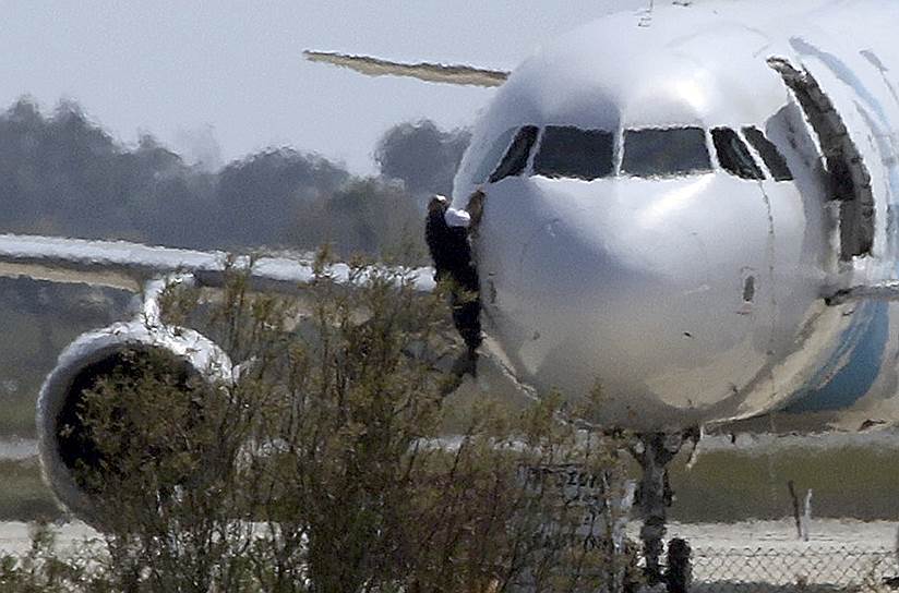 Ларнака, Кипр. Мужчина выбирается из окна кабины пилотов самолета EgyptAir, угнанного гражданином Египта Саифом эль-Дином Мустафой