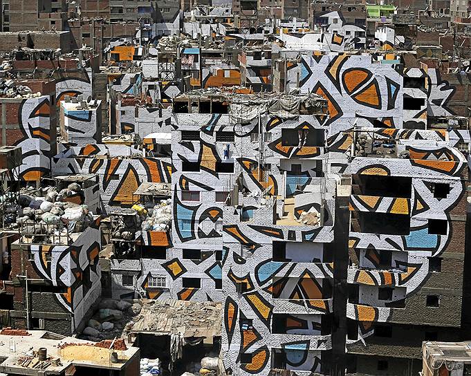 Каир, Египет. Граффити на домах в бедном районе, известном под названием «Мусорный город», созданное французско-тунисским художником Эль Сидом