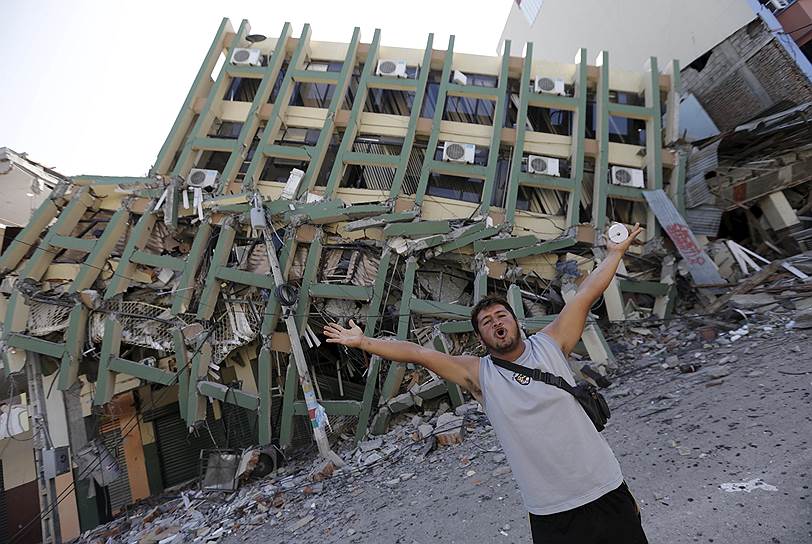 Портовьехо, Эквадор. Человек машет руками около разрушившегося в результате землетрясения здания