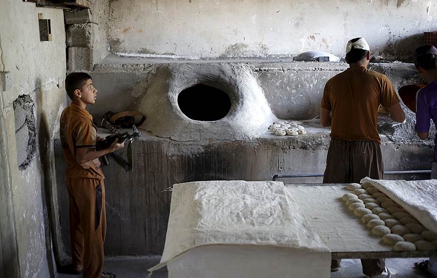 Туз-Хурмату, Ирак. Курдский мальчик с автоматом в местной пекарне