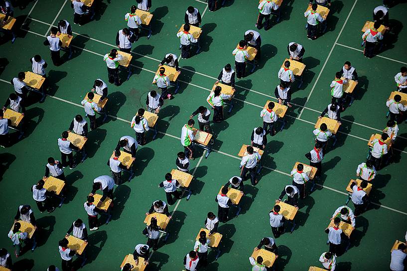 Шеньян, Китай. Ученики начальной школы играют в китайские шахматы во время мероприятия