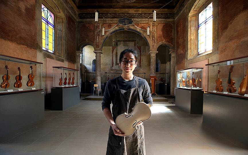 Японский студент Юма Мурата вместе с изготовленной им скрипкой внутри часовни в школе имени Антонио Страдивари 