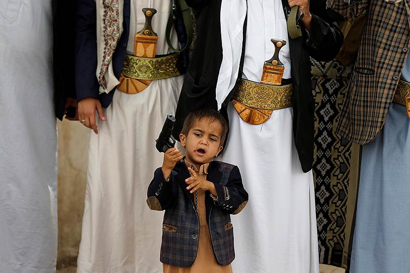 Сана, Йемен. Мальчик держит пистолет в окружении своих соплеменников, лояльных к движению хуситов