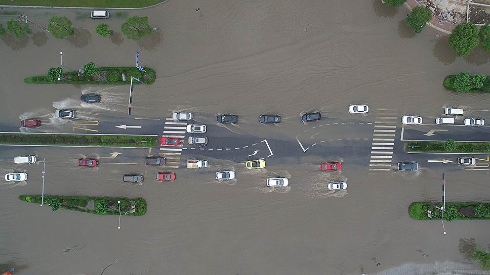 Цзясин, Китай. Машины едут по затопленной после сильного дождя трассе