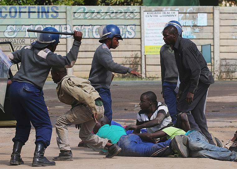 Хараре, Зимбабве. Полиция задерживает демонстрантов, после того как протест таксистов перерос в массовые беспорядки 