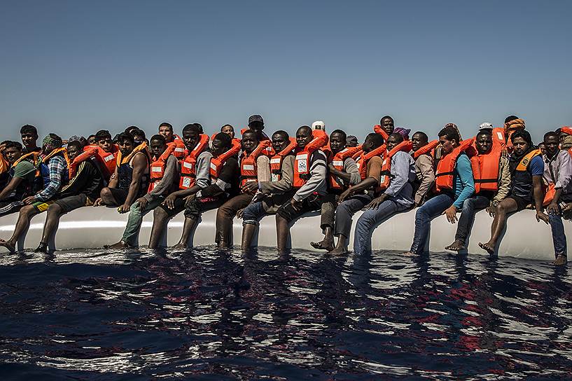 Сабрата, Ливия. Беженцы и мигранты из Эритреи, Мали, Бангладеш и других стран на борту спасательной шлюпки в Средиземном море