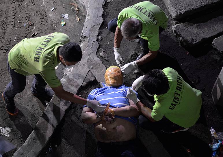 Манила, Филиппины. Работник похоронного бюро снимают клейкую ленту с головы наркодельца, убитого народными борцами с наркомафией