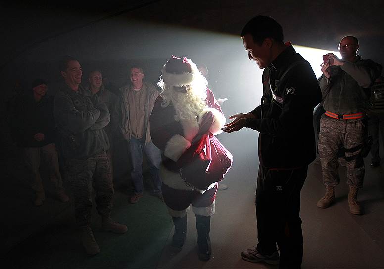 Американский солдат в костюме Санта-Клауса поздравляет сослуживцев с Рождеством на авиабазе в Баграме