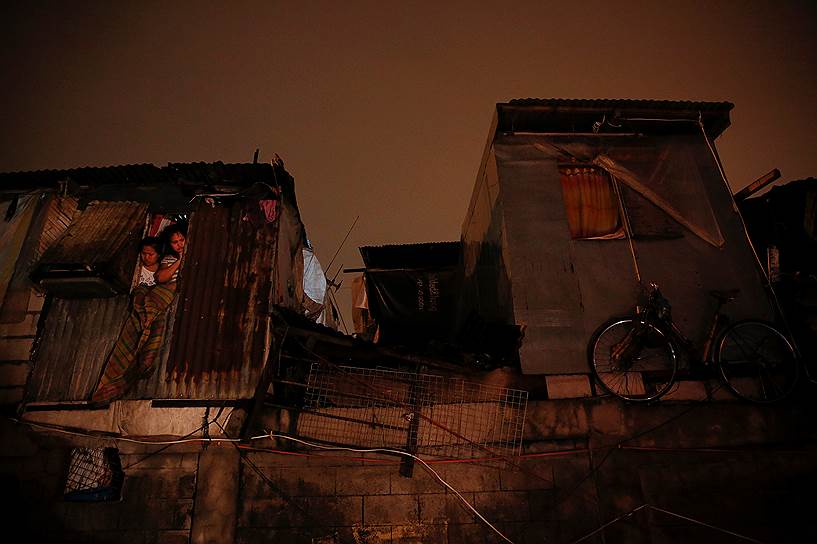 Манила, Филиппины. Жители трущоб смотрят на место, где в перестрелке с полицией был убит подозреваемый в наркоторговле мужчина