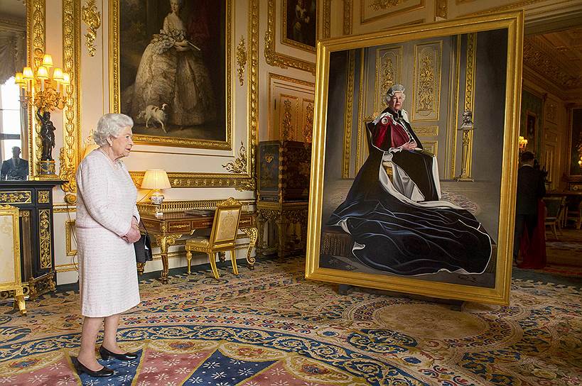Виндзорский замок, Великобритания. Королева Елизавета II рассматривает свой новый портрет, созданный в честь 60-летия ее сотрудничества с британским Красным Крестом