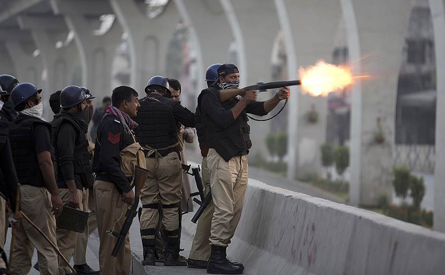 Равалпинди, Пакистан. Полицейский выпускает снаряд слезоточивого газа в толпу во время антиправительственных митингов