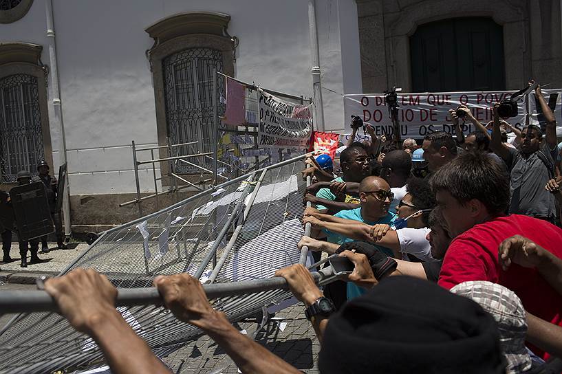 Рио-де-Жанейро, Бразилия. Демонстранты рушат забор вокруг Законодательной ассамблеи города во время акции против планов правительства заморозить социальные выплаты на 20 лет