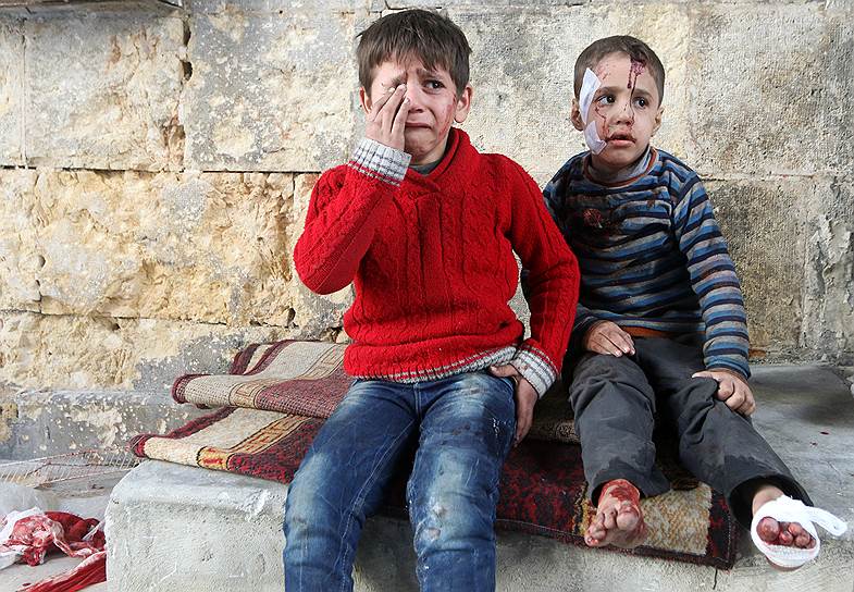Алеппо, Сирия. Дети, раненные во время бомбардировки, сидят у госпиталя 